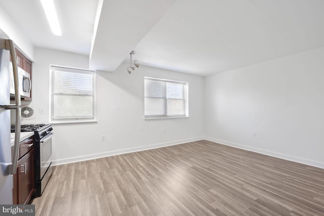 kitchen with baseboards, a healthy amount of sunlight, stainless steel gas range oven, and light wood-type flooring