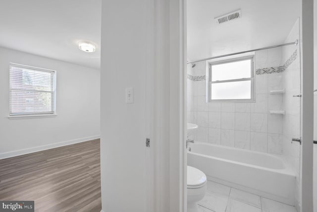 full bathroom featuring shower / bathing tub combination, visible vents, toilet, and baseboards