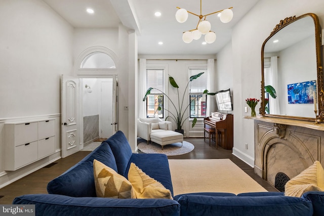 living room featuring baseboards, recessed lighting, wood finished floors, and an inviting chandelier
