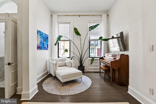 living area with dark wood-type flooring and baseboards