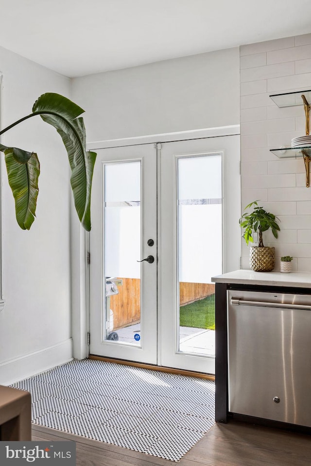 doorway with wood finished floors, a healthy amount of sunlight, french doors, and baseboards
