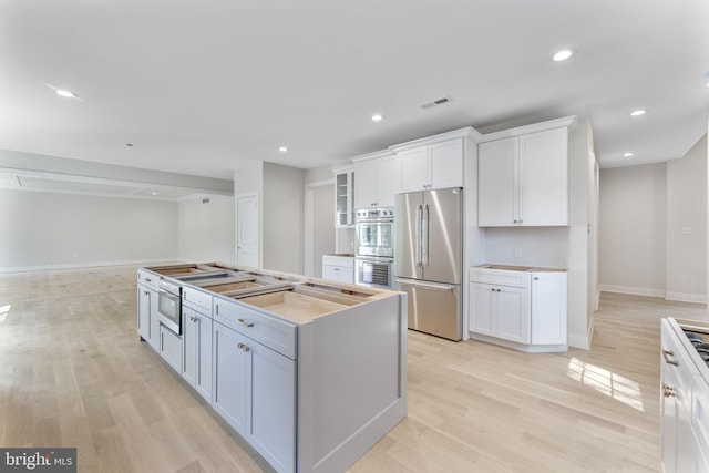 17 Hickory Ln, Malvern, PA 19355 - kitchen featuring visible vents, baseboards, light wood-type flooring, white cabinetry, and stainless steel appliances