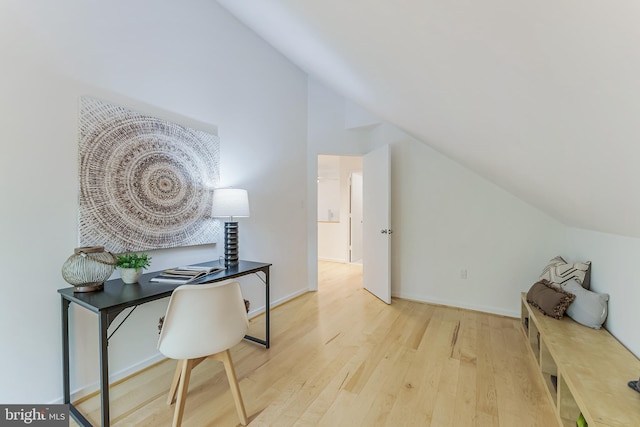 office with wood finished floors and vaulted ceiling