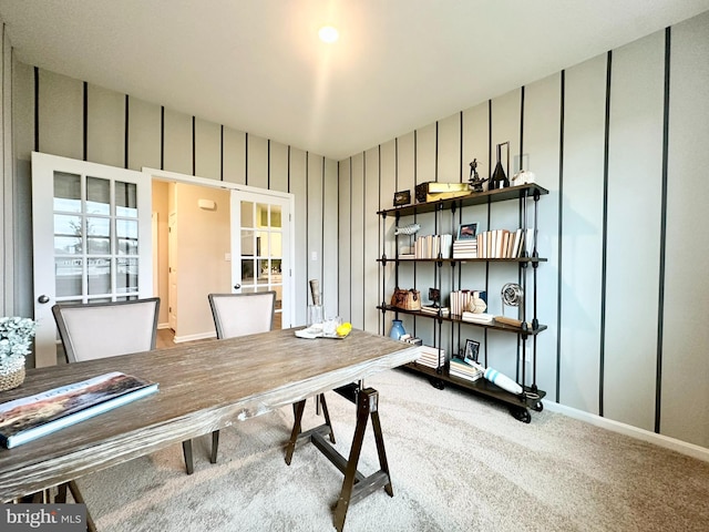 carpeted home office with a decorative wall and baseboards