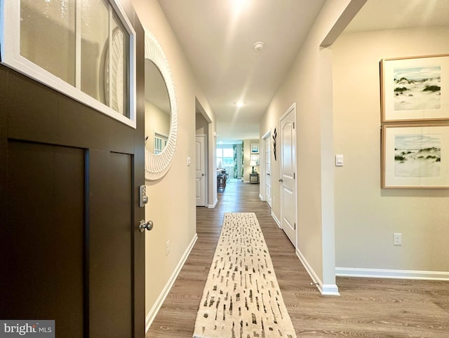 hallway with wood finished floors, baseboards, and recessed lighting