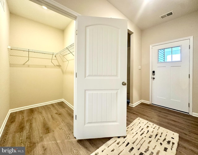 foyer featuring visible vents, baseboards, and wood finished floors