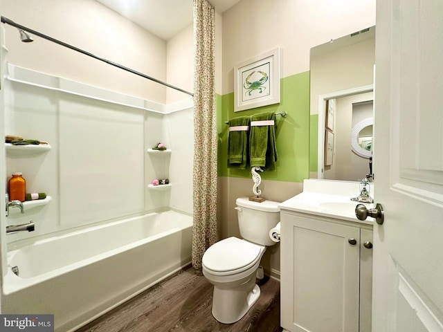 bathroom with toilet, wood finished floors, shower / bath combo with shower curtain, and vanity