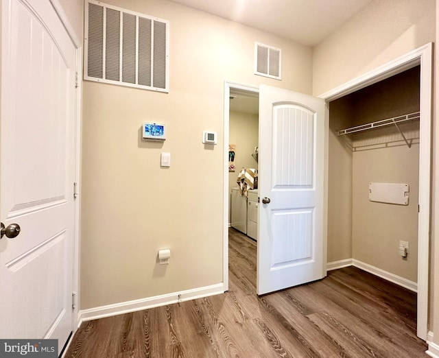 laundry room with visible vents, baseboards, and wood finished floors