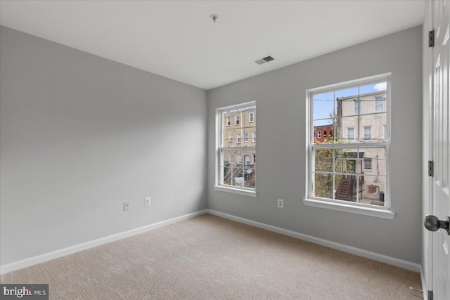 empty room with baseboards, carpet, and visible vents