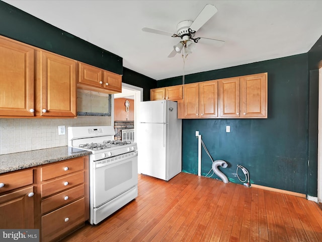 kitchen with tasteful backsplash, white appliances, light wood-style floors, and a ceiling fan
