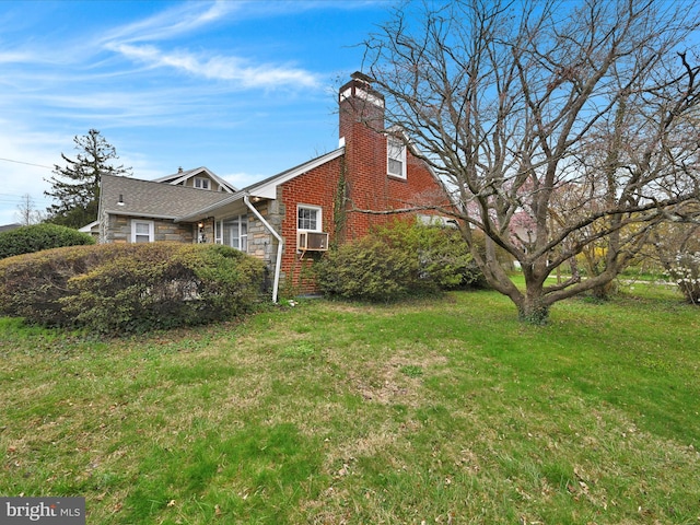 view of side of property with a chimney, stone siding, and a yard
