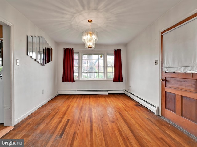 unfurnished dining area with baseboards, an inviting chandelier, baseboard heating, wood finished floors, and a baseboard heating unit