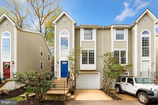 townhome / multi-family property featuring a garage and aphalt driveway