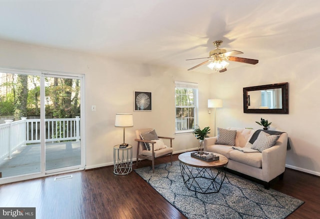 living room with baseboards, ceiling fan, wood finished floors, and visible vents
