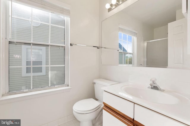 bathroom featuring vanity, tile patterned flooring, a stall shower, and toilet