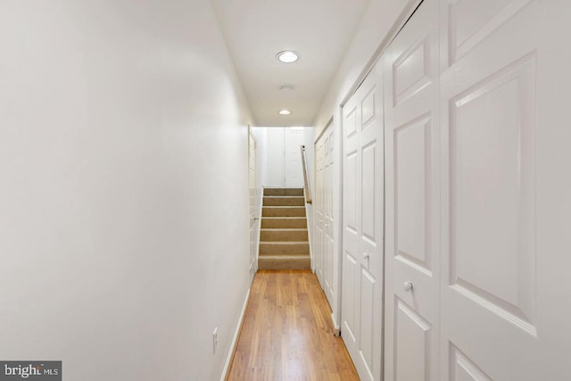 corridor featuring recessed lighting, baseboards, light wood-style flooring, and stairs
