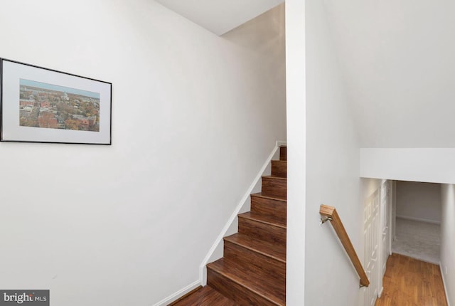 stairway featuring baseboards and wood finished floors