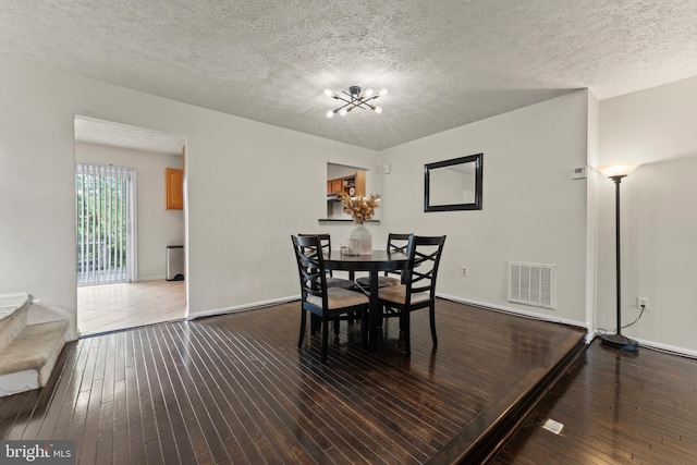 10633 Campus Way S, Upper Marlboro, MD 20774 - dining space featuring a chandelier, a textured ceiling, hardwood / wood-style floors, and visible vents