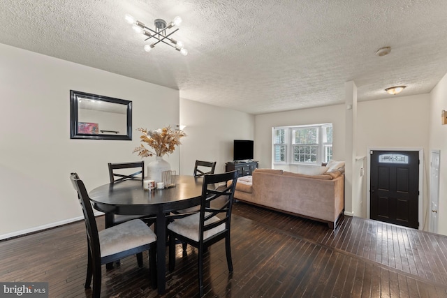10633 Campus Way S, Upper Marlboro, MD 20774 - dining room with dark wood finished floors, a textured ceiling, baseboards, and a notable chandelier