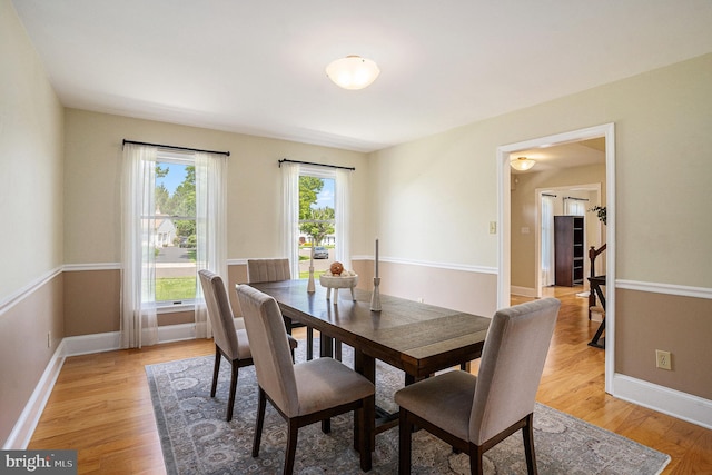 dining space with light wood-style flooring and baseboards