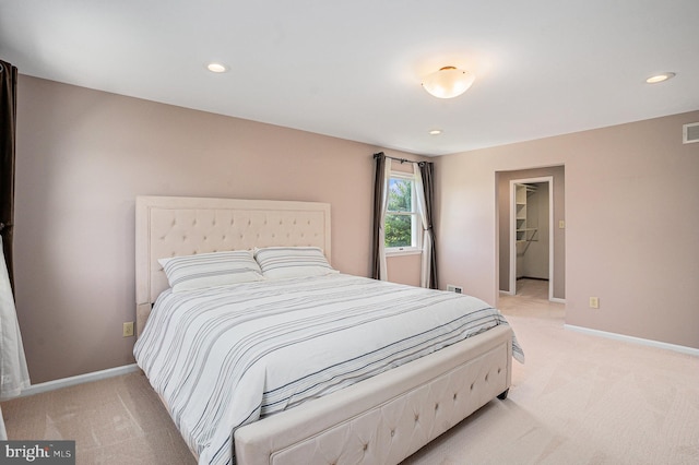 bedroom featuring light carpet, baseboards, recessed lighting, and a spacious closet