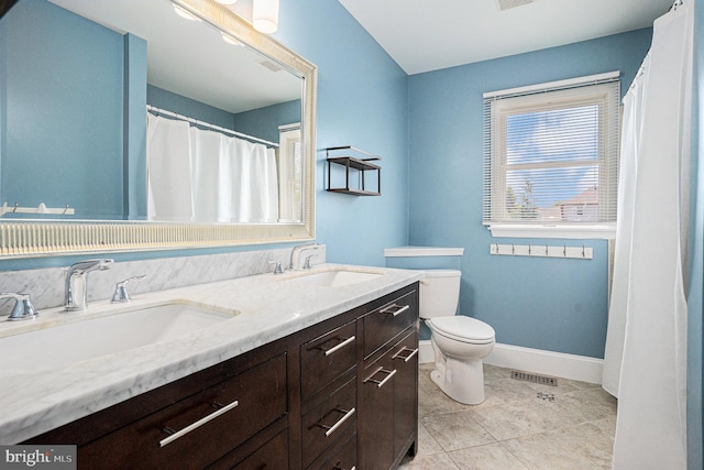 full bath featuring toilet, double vanity, baseboards, and tile patterned flooring