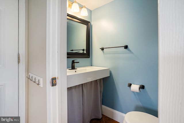 half bath featuring toilet, baseboards, and tile patterned flooring