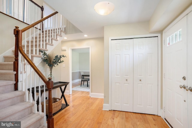 foyer entrance featuring recessed lighting, light wood-style floors, baseboards, and stairway