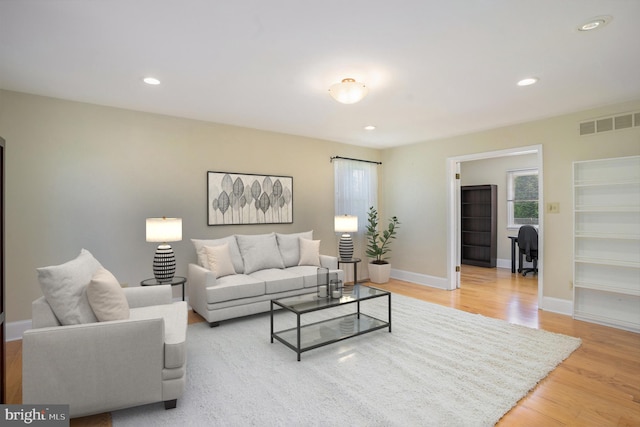 living room with light wood-style floors, baseboards, and recessed lighting