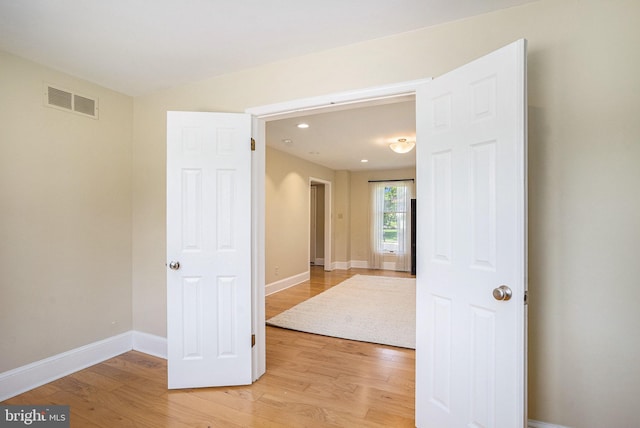 unfurnished room featuring light wood finished floors, baseboards, and recessed lighting