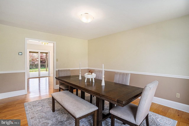 dining space featuring baseboards and light wood-style floors