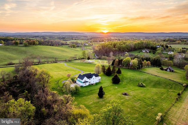 aerial view at dusk with a mountain view and a rural view