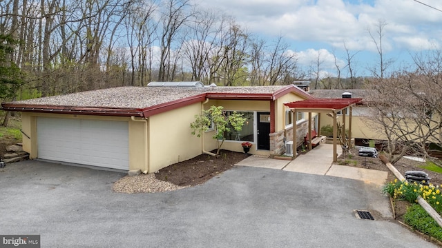 view of front of house with stucco siding and a detached garage