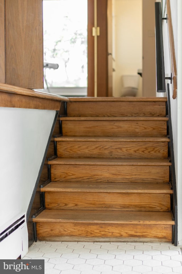 stairway featuring baseboard heating