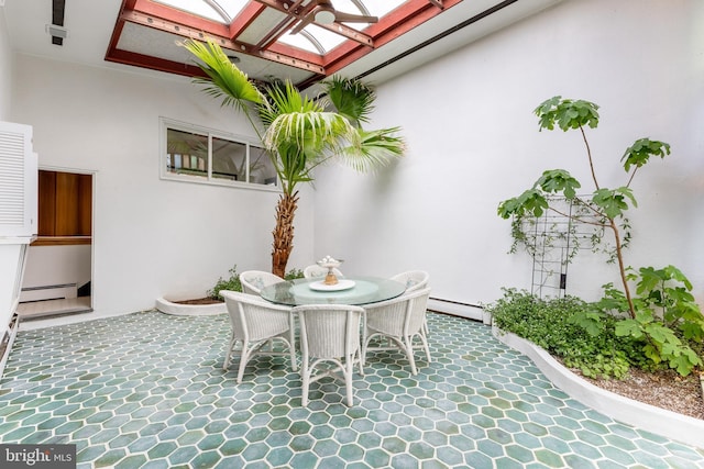 view of patio / terrace featuring a baseboard heating unit and outdoor dining area