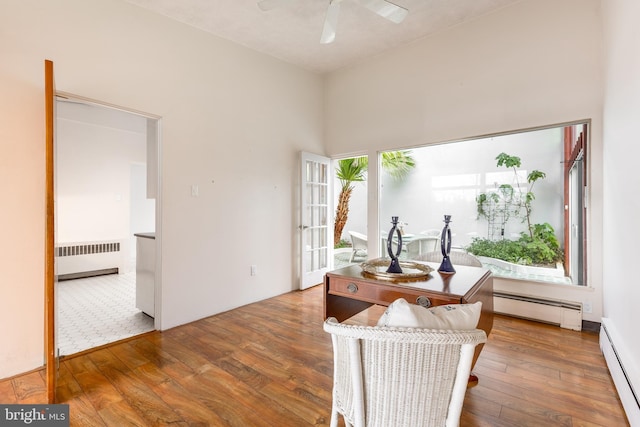 interior space featuring wood-type flooring, a ceiling fan, baseboard heating, and radiator heating unit