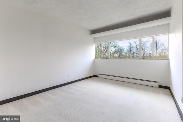 empty room featuring a baseboard heating unit, a textured ceiling, carpet, and baseboards