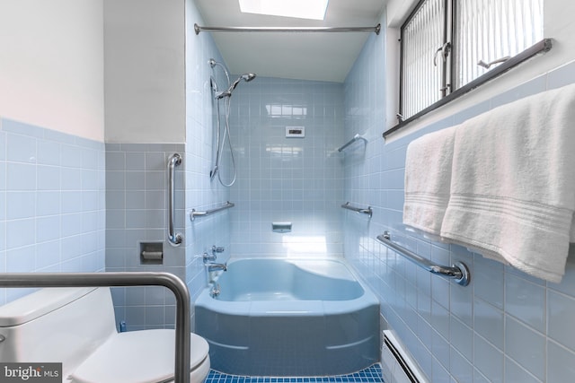 bathroom featuring toilet, tile walls, shower / bath combination, and a baseboard radiator