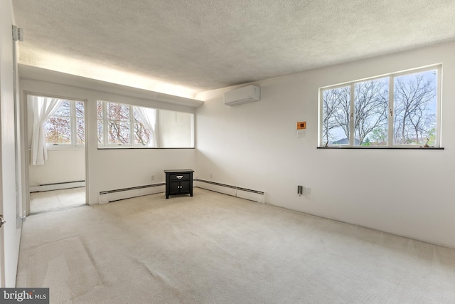 spare room with a wall unit AC, a baseboard heating unit, a textured ceiling, and carpet flooring