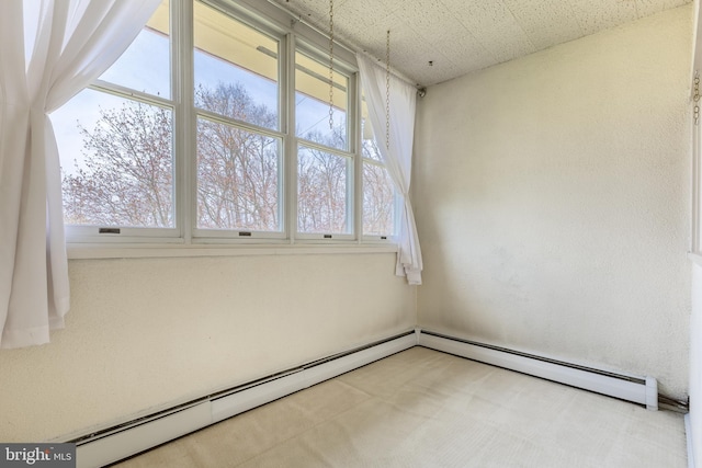 spare room with a baseboard heating unit and carpet floors