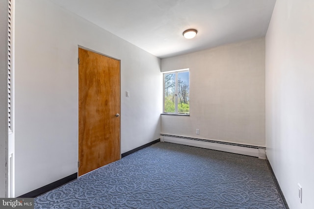 carpeted empty room featuring baseboards and a baseboard radiator