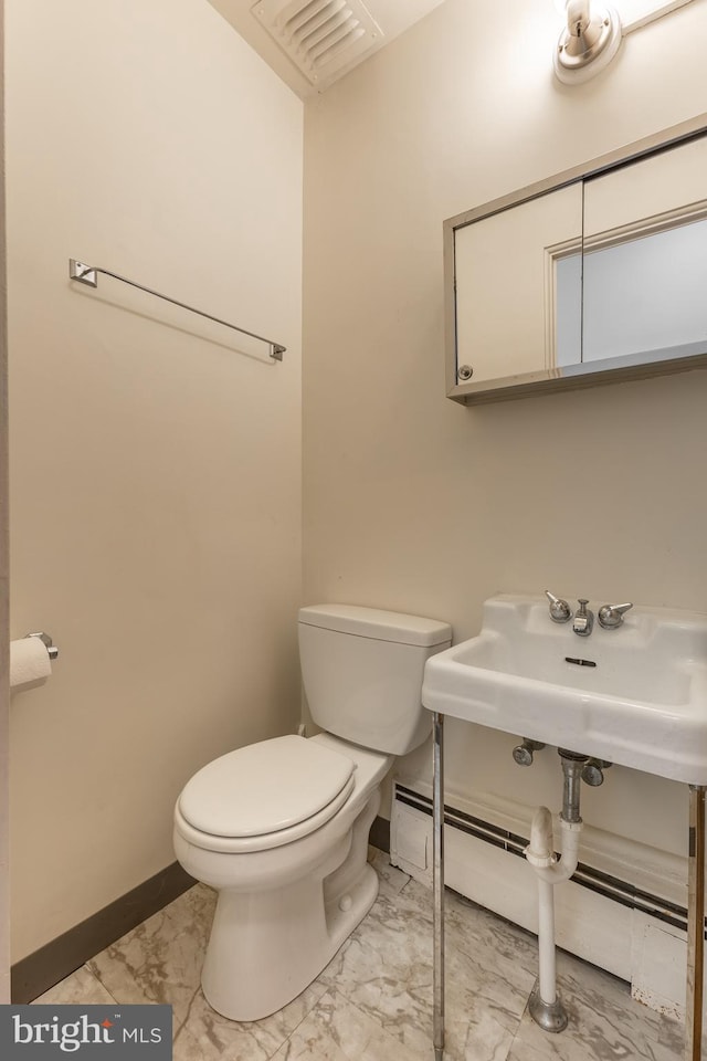 bathroom with toilet, marble finish floor, visible vents, and baseboards