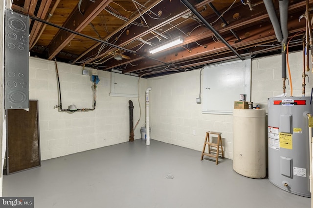 unfinished basement featuring concrete block wall and electric water heater
