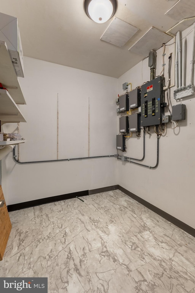 basement with electric panel and baseboards