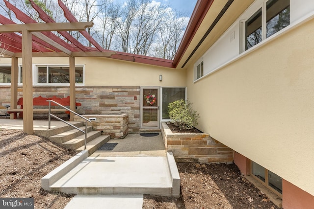property entrance featuring stucco siding and stone siding