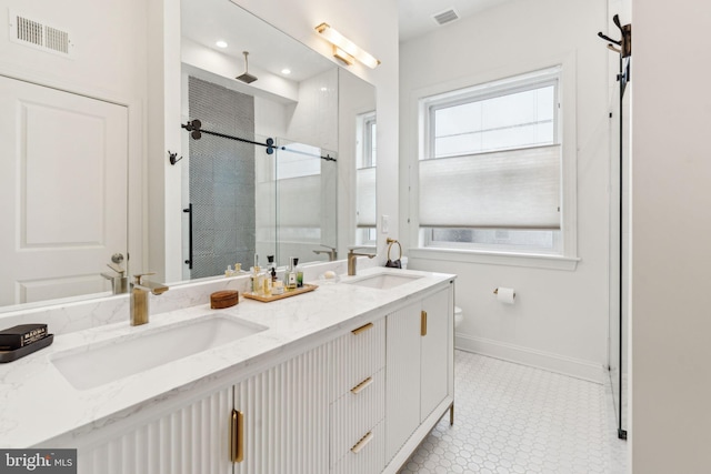 full bath featuring a shower stall, visible vents, baseboards, and a sink
