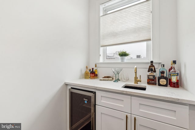 bar with plenty of natural light, wine cooler, a sink, and wet bar