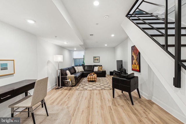 living room featuring stairway, recessed lighting, and light wood-style flooring