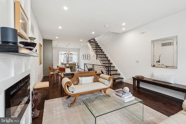 living room with stairway, a fireplace with flush hearth, wood finished floors, and recessed lighting