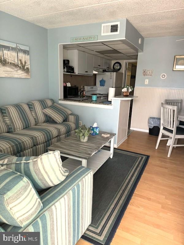 504 E 17th Ave Unit 206, Wildwood, NJ 08260 - living area featuring wood finished floors, visible vents, and a wainscoted wall